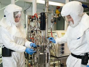 A researcher and student researcher in a laboratory setting, wearing full protective suits. Image courtesy CASTL