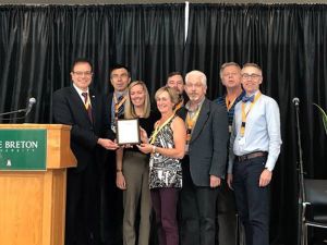 Professors from the Manning School of Business receive an award on stage.