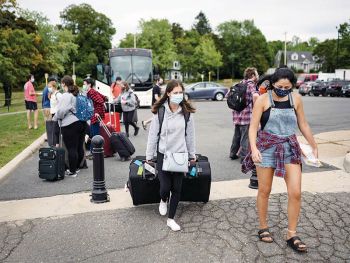 First-year Alexandra Leeder departs a coach bus with her luggage. Photo courtesy Darren Calabrese, Maclean's