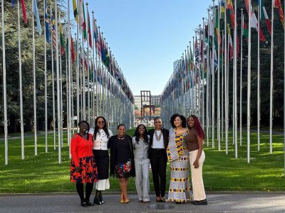 The Acadia delegation poses outside the United Nations Office in front of the array of flags and the Broken Chair monument.