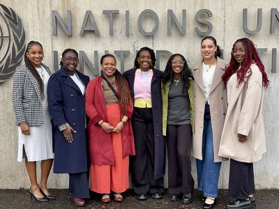 The Acadia delegation smiles for a group photo in front of the United Nations sign in Geneva.