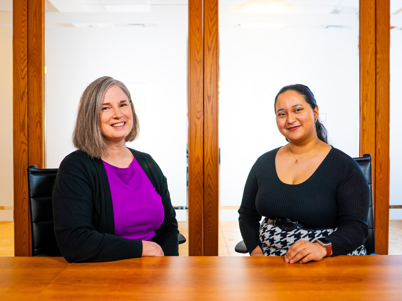 Dr. Kristin Williams and Victoria Martinez smile while posing for a photo in a Patterson Hall boardroom.