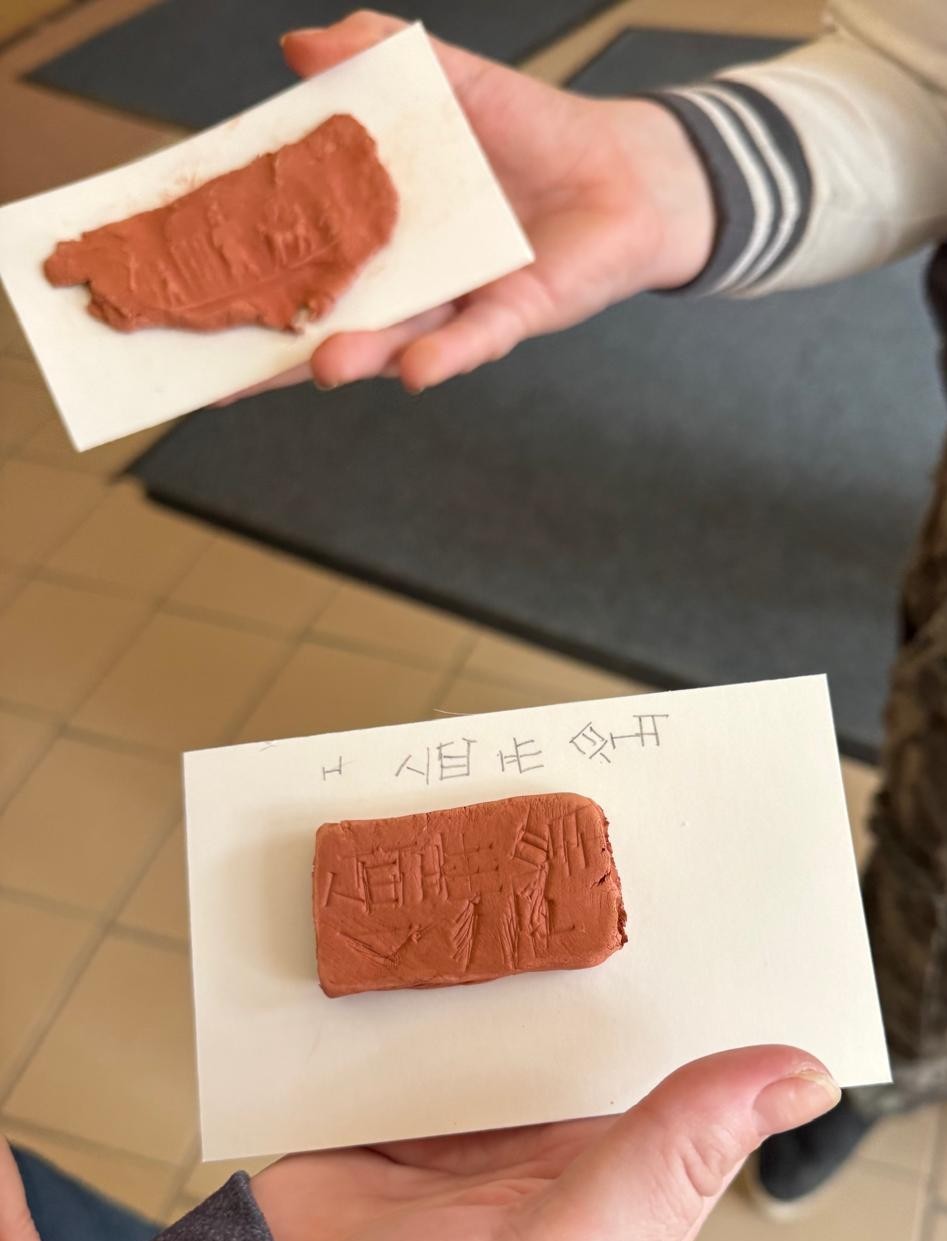 A close-up view of 'homemade' cuneiform tablets inscribed with writing that students have made with clay.