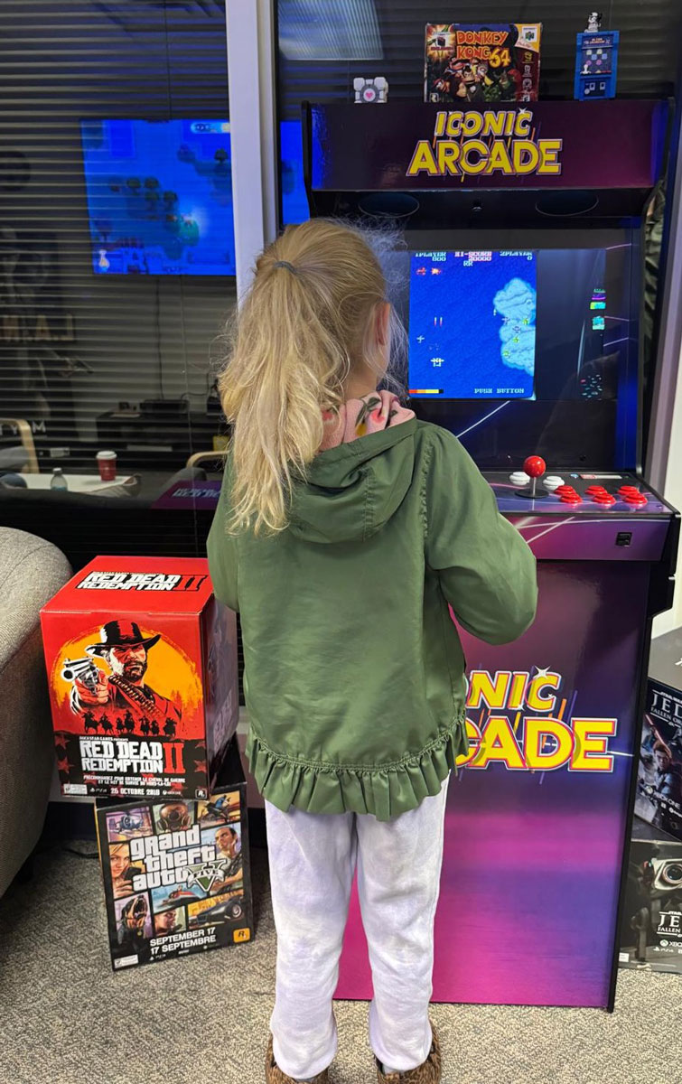 A child stands in front of an arcade machine and other video game memorabilia at the Acadia Centre for Digital Play