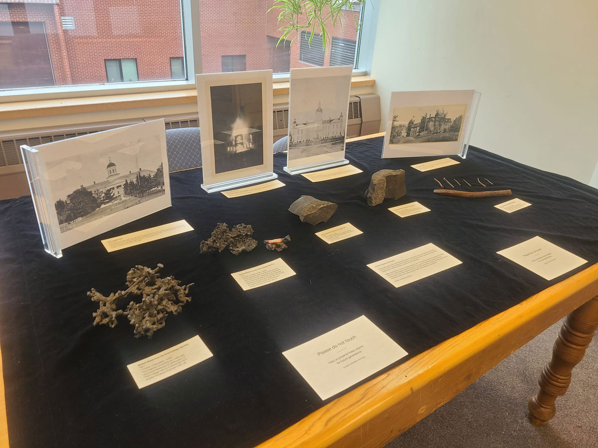 A library display of artifacts and photos related to the fires that destroyed Acadia's first two College Halls.
