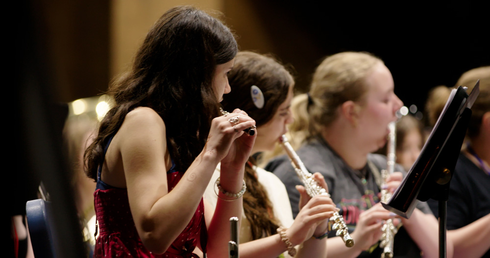 Young flautists performing in an Acadia concert space.