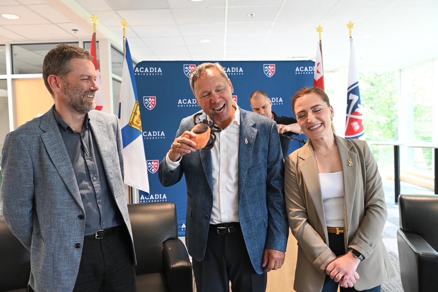 Nova Scotia Minister of Advanced Education jokingly mimes eating a tick plushie while standing next to Dr. Faraone
