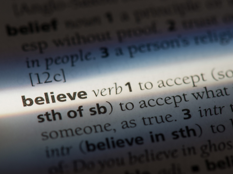 A closeup of the word "believe" on the page of a dictionary.