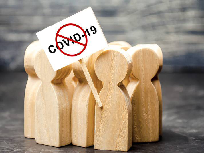 Wooden figures holding a 'No COVID-19' placard. RF Stock image licensed by Saltwire.